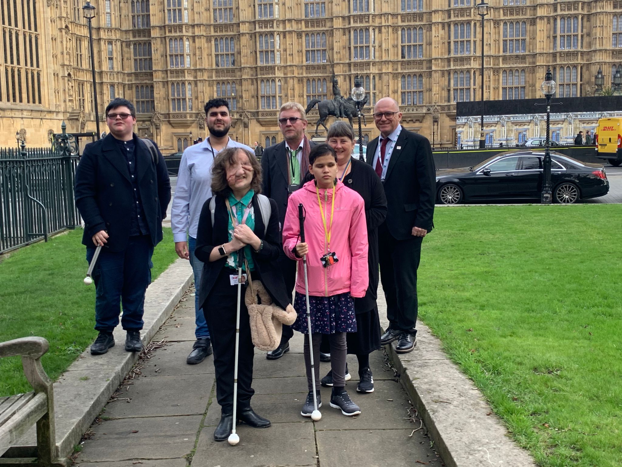 a group of 7 staff and students standing in front of the Houses of Parliament