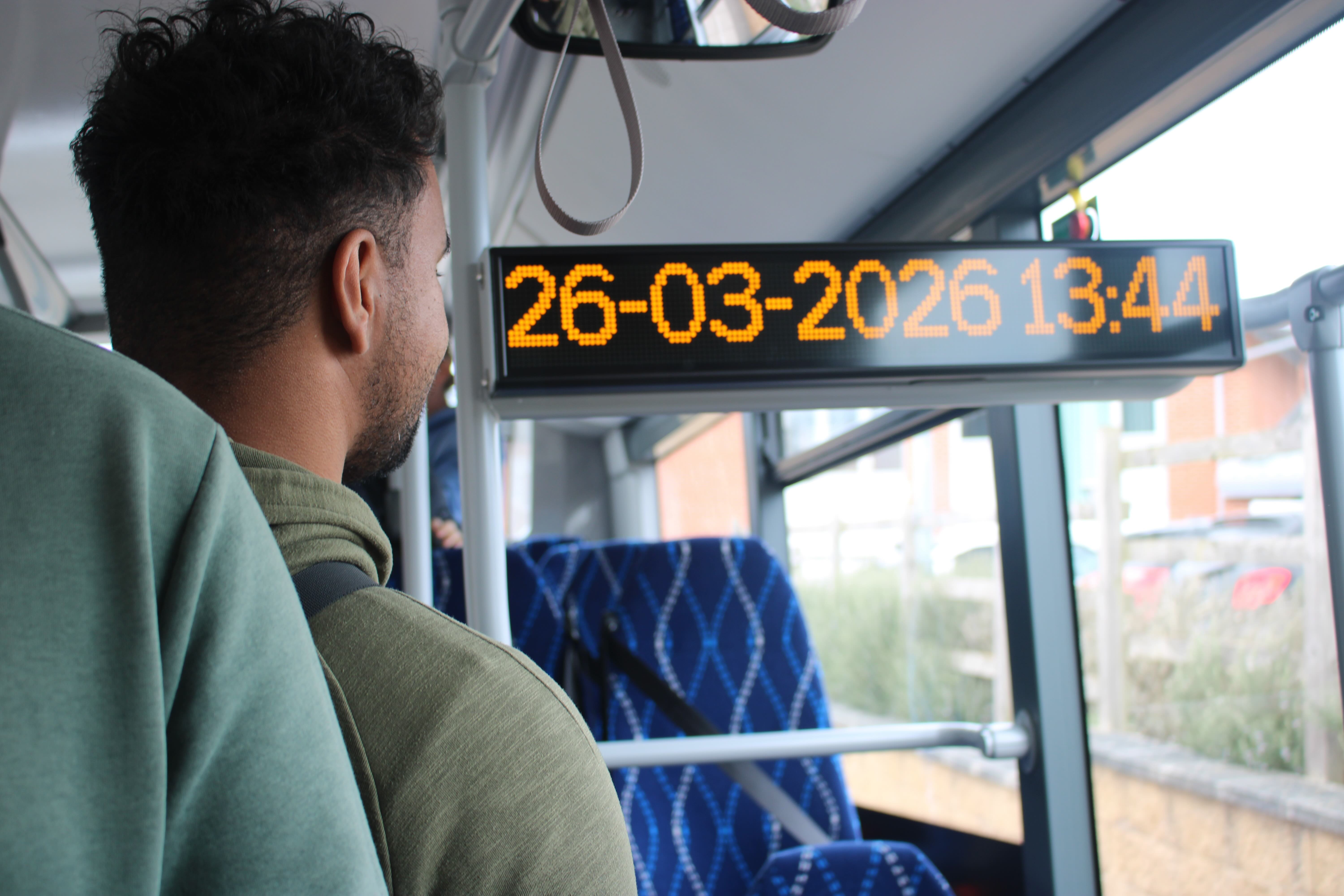 A male student looking at the brightly lit low level digital sign