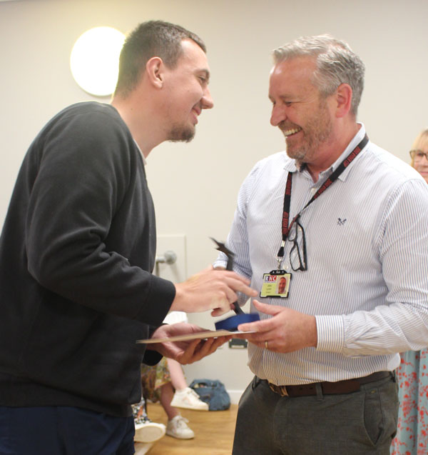 A student being handed his award from a member of staff