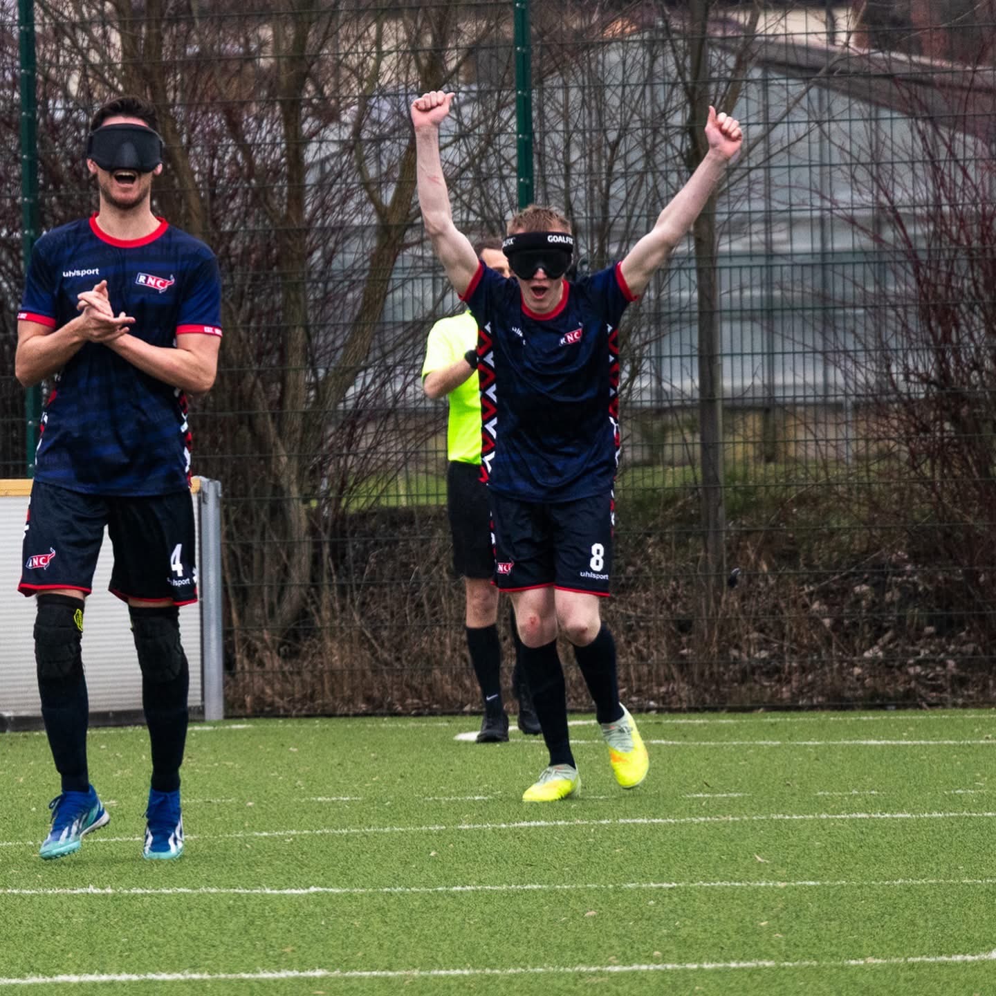2 RNC players on the field celebrating - one smiles and claps the other has his arms in the air 