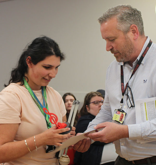 A student is presented with an award and certificate