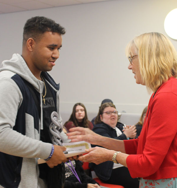 a student being handed an award from a member of staff