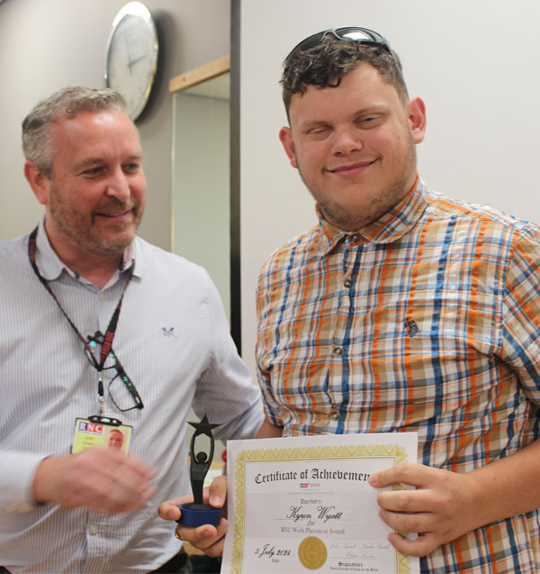 A student showing off his newly acquired certificate and award