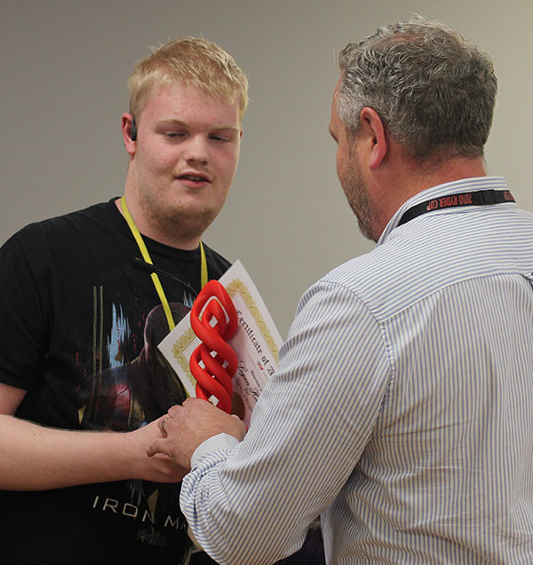 A student accepting his certificate and award from a member of staff