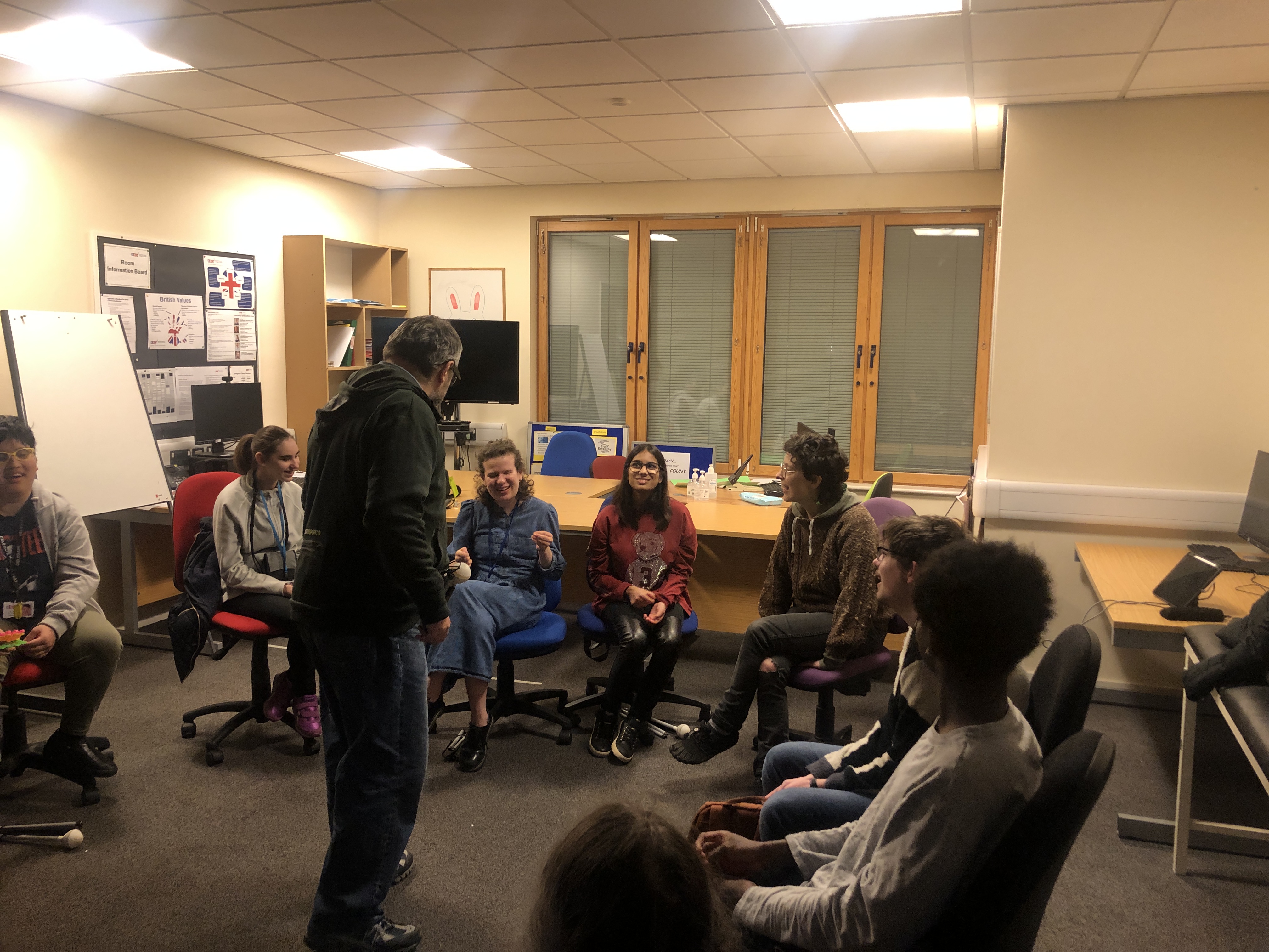 Steve engages with the group who are sitting around him on chairs in a circle