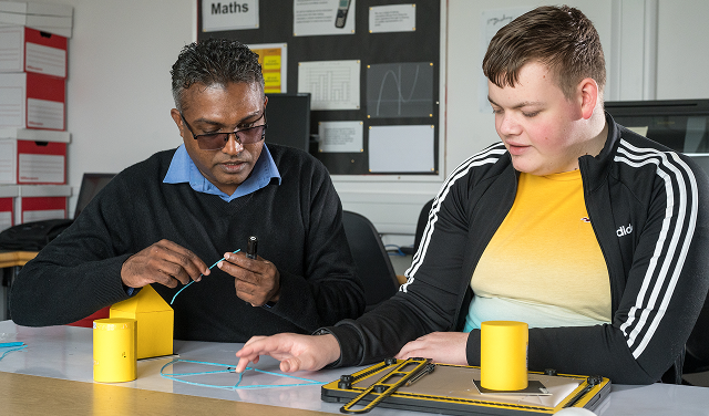 Photo of a teacher and a student working together on a project.
