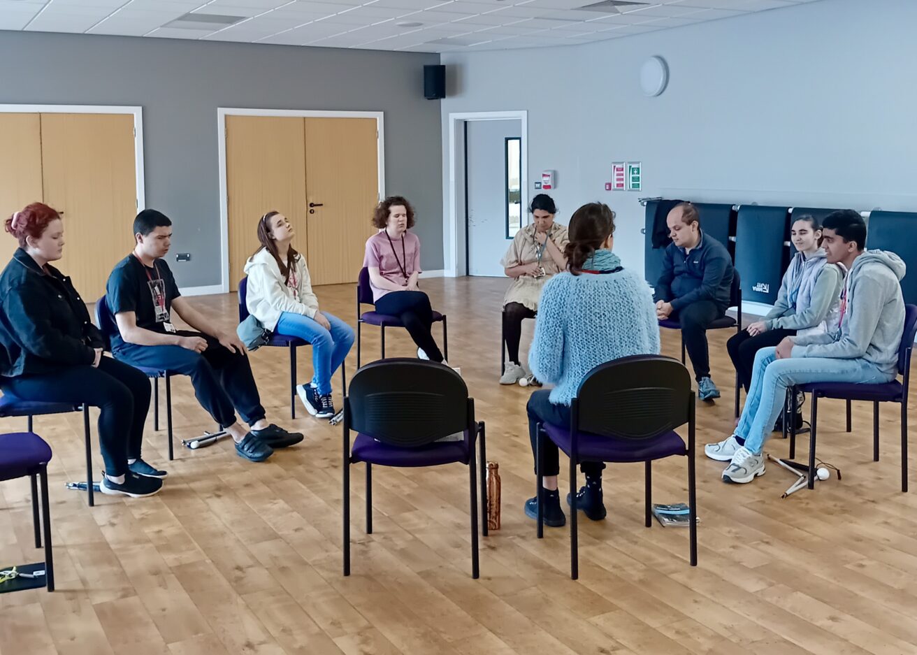 The group of students sit in a circle around Helena as she explains what will happen during the session