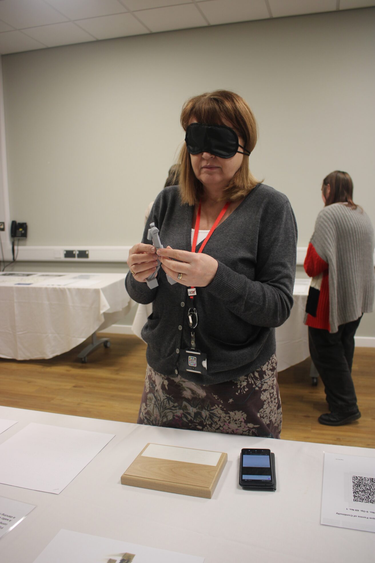 Karen explores the 3D model of Unique Forms of Continuity in Space with her hands while blindfolded