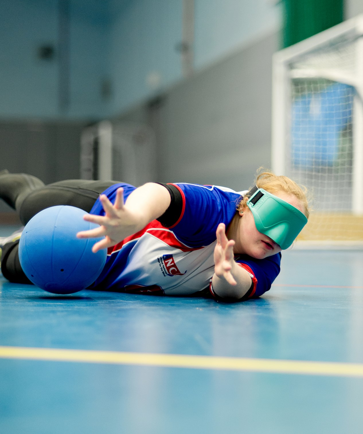 An image of a goalball player reaching for the ball.