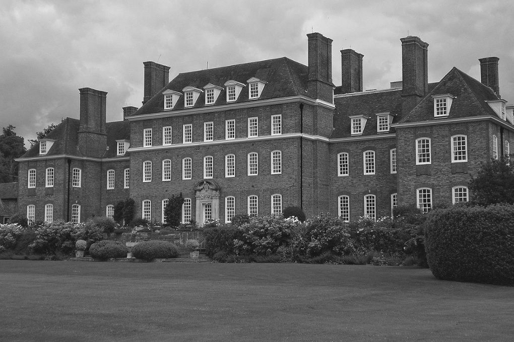 Black and white image of Great Maytham in Rolvenden, West Kent. It is a large stately house, with 3 floors, and windows in the roof.