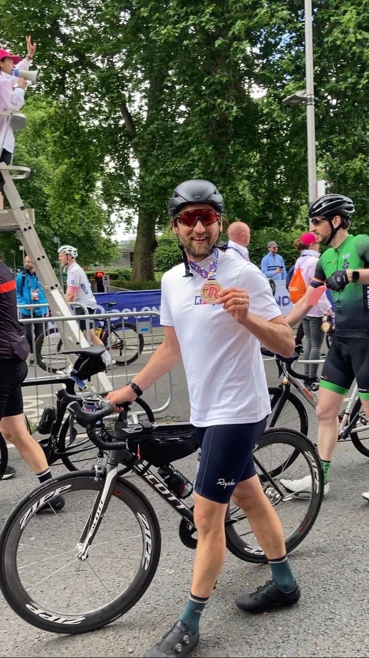Andrew pictured holding his medal and bike after the race