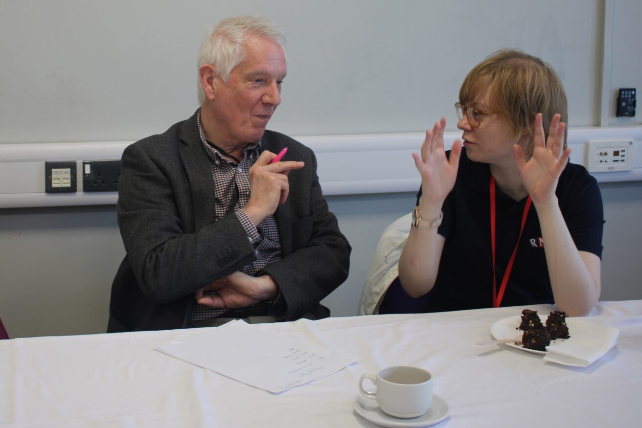 a team comprising one male governor and volunteer and a female volunteer discussing their answer