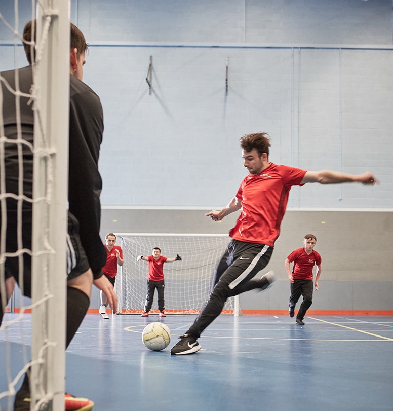 Photo of someone kicking a ball whilst playing partially sighted futsal