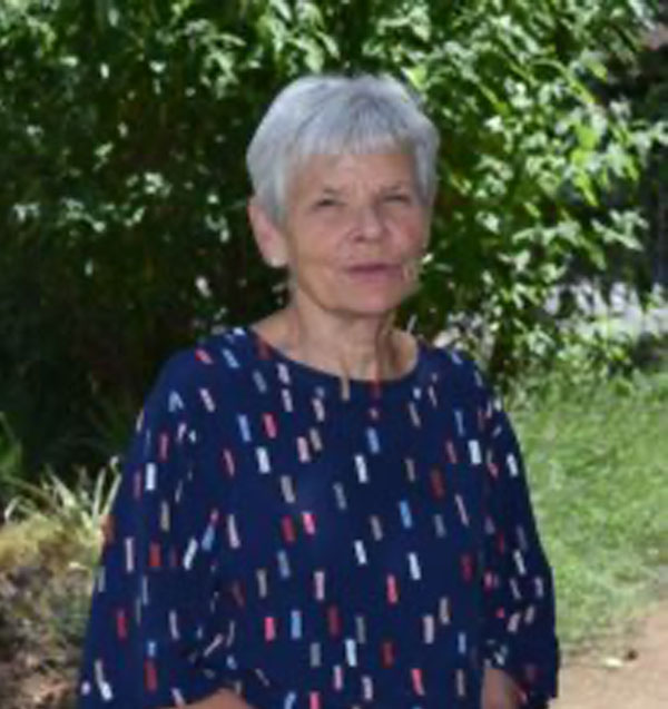 Headshot of Suzanne Penny, she has short grey hair and is wearing a blue long sleeved top.