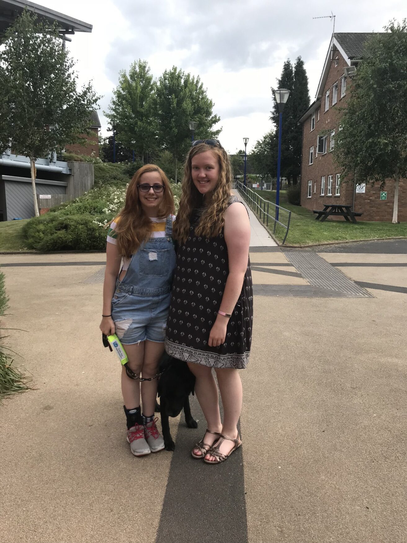 Tiri and her friend Emily, outside Stephens Hall with Darby the guide dog.