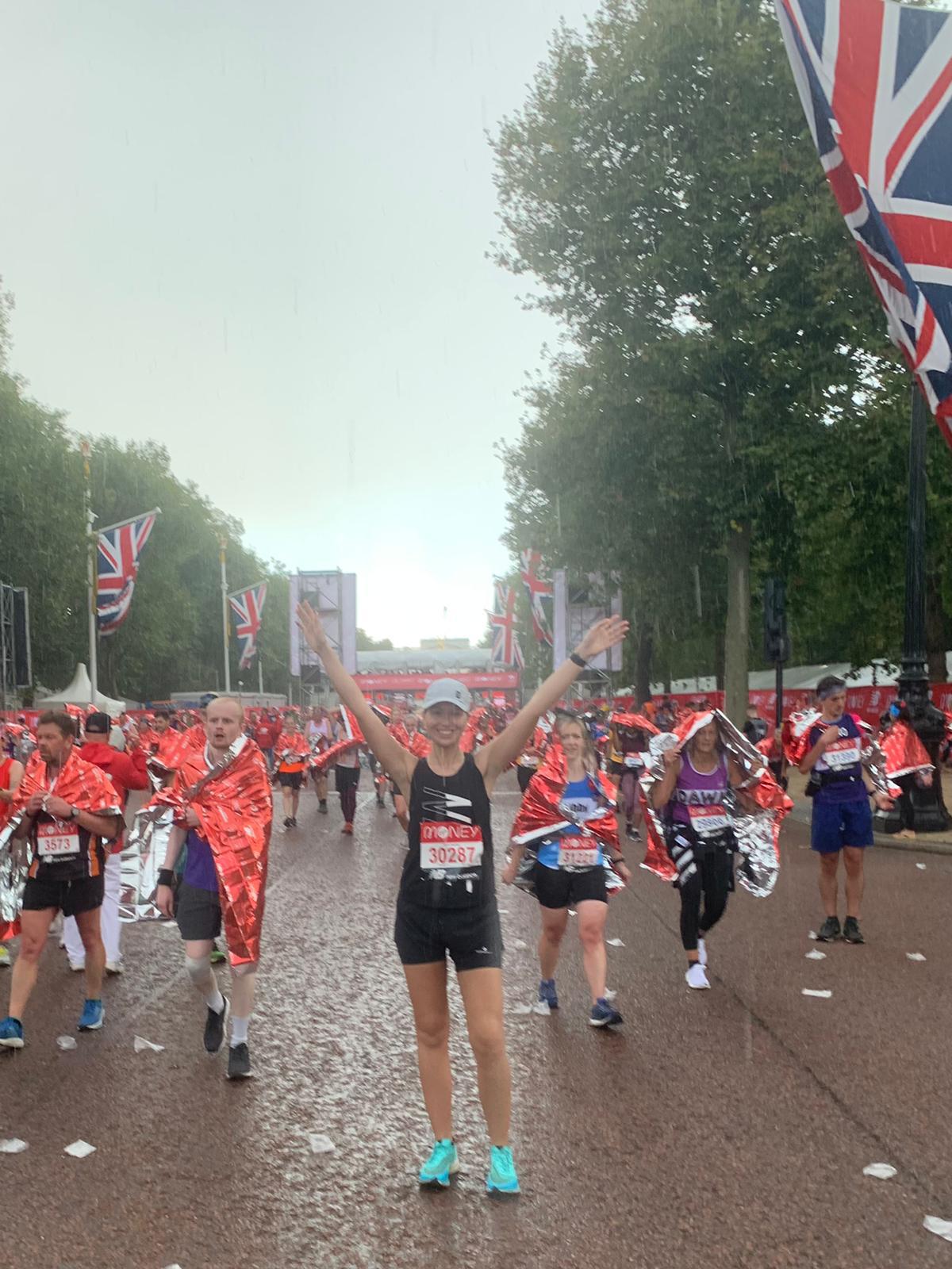 Photo of Tara at the end of the race celebrating with her arms in the air