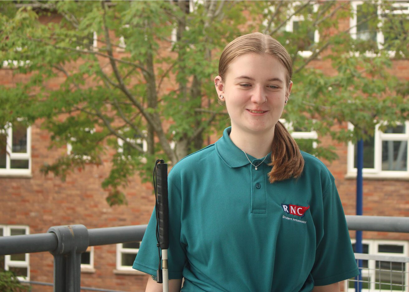 Head and shoulders portrait of Dayzie wearing her dark green student ambassador polo shirt