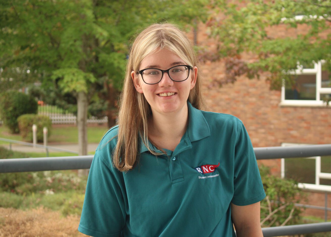 Head and shoulders portrait of Ana wearing her dark green student ambassador polo shirt