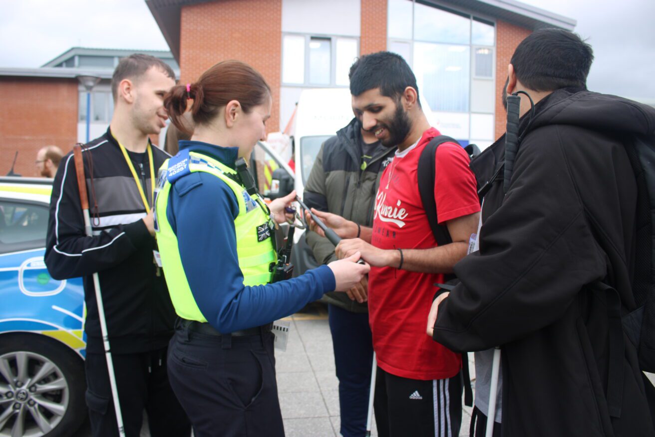 A student EPQ where the emergency services were invited in. Here a WPC is allowing a student to handle her police baton - three other students are waiting their turn