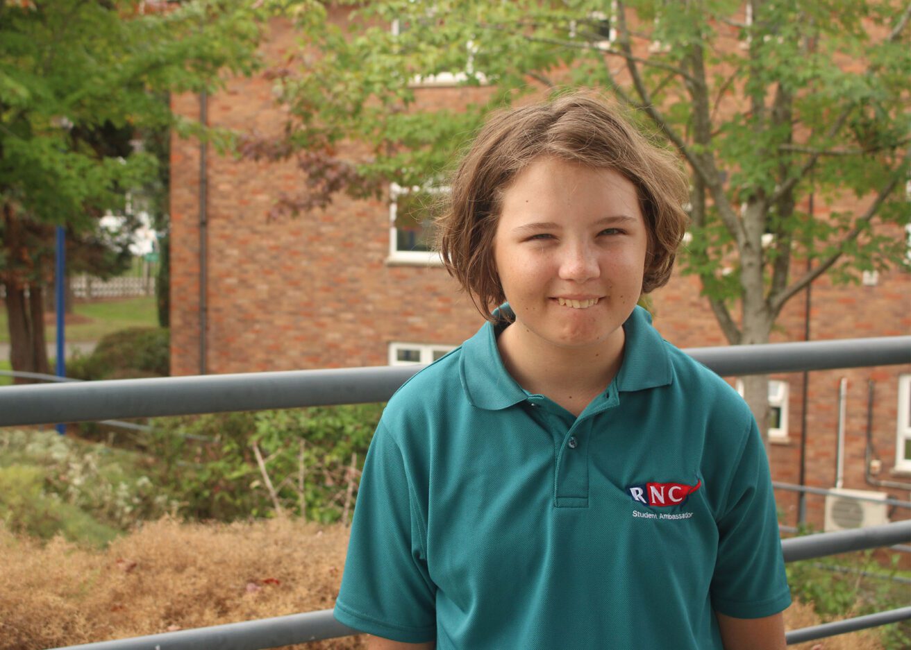 Head and shoulders portrait of Skye wearing her dark green student ambassador polo shirt